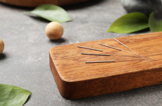 Board with needles for acupuncture on dark table